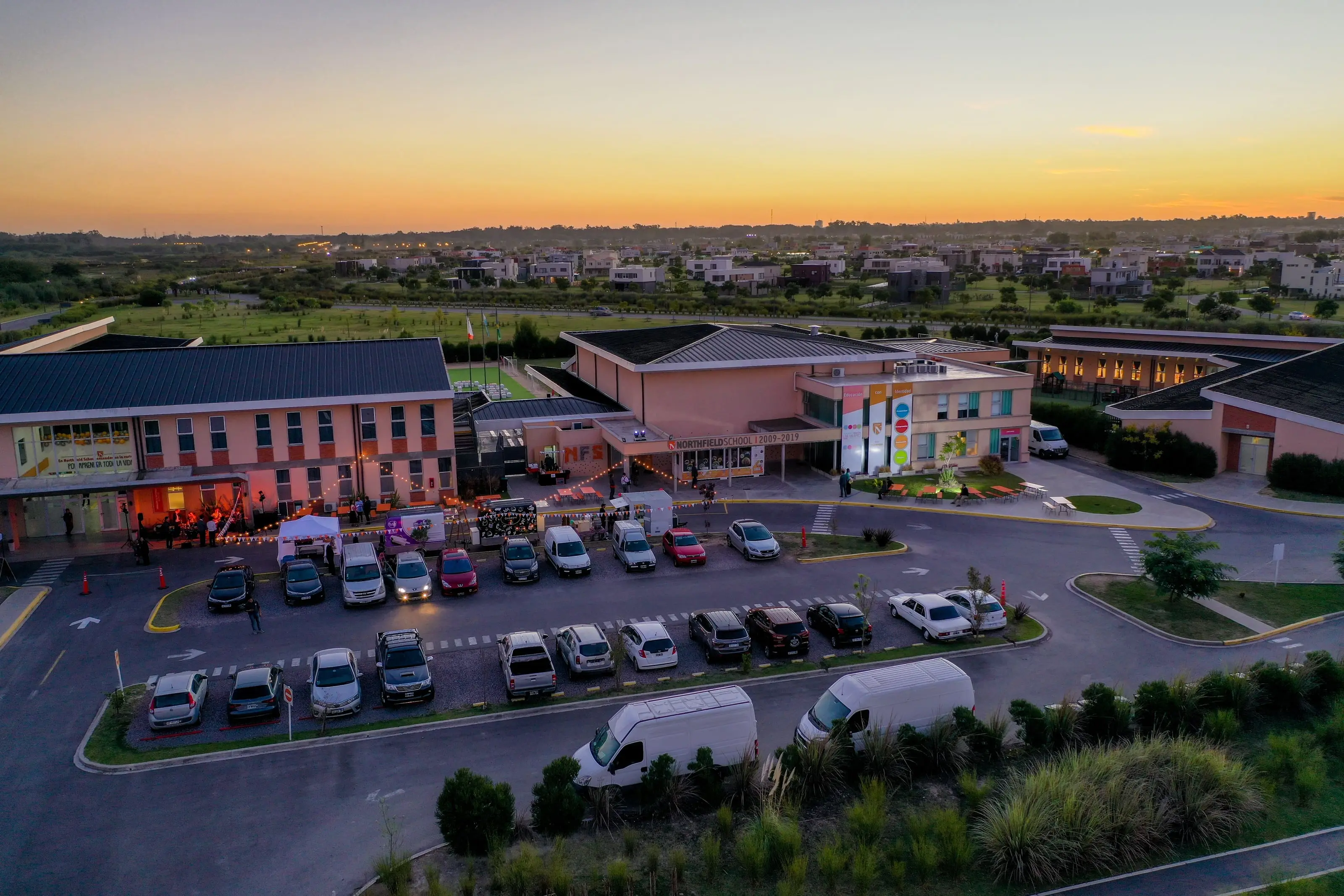 Northfield School Puertos desde el aire, al atardecer: el campus completo y la playa de estacionamiento llena